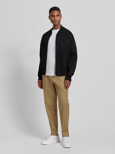 Männermodel trägt Oversized Sweatjacke aus Baumwoll-Mix Modell 'DROMZIP' von HUGO, Optik: Unifarben, Passform: Oversized, Reißverschluss, Logo-Patch, Motiv-Stitching, College-Kragen, Langarm, Ärmelabschluss und Rumpfabschluss: Gerippt, seitliche Eingrifftaschen, Materialverarbeitung: Sweat, Ganzkörperansicht von vorne.