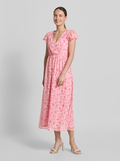 Modelka nosi Midikleid im Allover-Look Modell 'EMMA' od Vila, różowy kolor, kwiatowy wzór, dekolt w serek, długość pleców 126 cm, szerokość w rozmiarze 36: 42 cm, widok całej sylwetki z przodu.