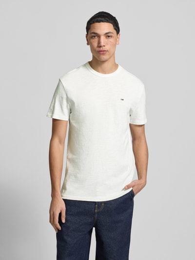 Männermodel trägt Regular Fit T-Shirt aus reiner Baumwolle von Tommy Jeans, unifarben, Rundhals, kurzarm, Ganzkörperansicht von vorne.