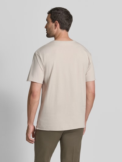 Männermodel trägt T-Shirt mit Rundhalsausschnitt und Rollsaum von Scotch & Soda, Baumwolle, Relaxed Fit, Rückansicht, Ganzkörperansicht