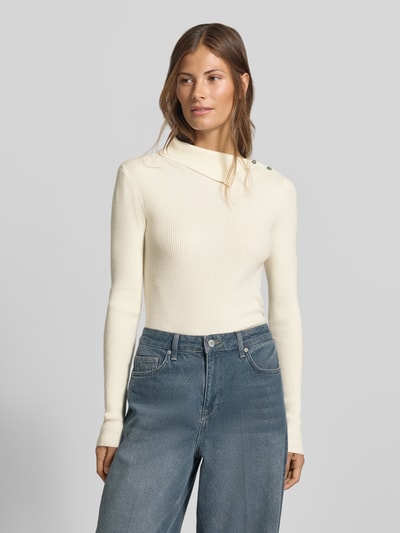 Frauenmodel trägt Slim Fit Pullover aus Viskose-Mix in Strick-Optik von MYON in Creme mit Knopfleiste, lange Ärmel, Ganzkörperansicht von vorne.