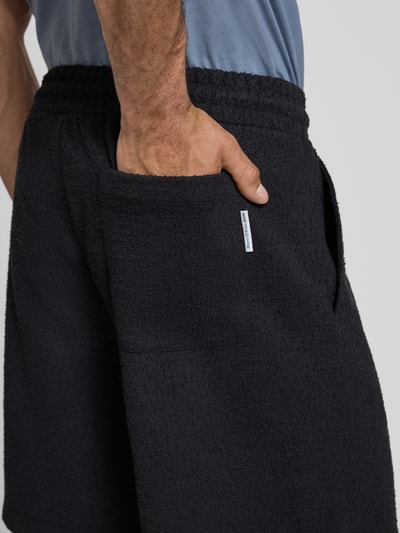Männermodel trägt Regular Fit Sweatshorts aus Baumwoll-Mix von Marc O'Polo Denim, Optik: Unifarben, Materialverarbeitung: Bouclé, Label Patch, seitliche Eingrifftaschen, Gesäßtasche, Bundabschluss elastisch mit Tunnelzug, Nahaufnahme Oberkörper.