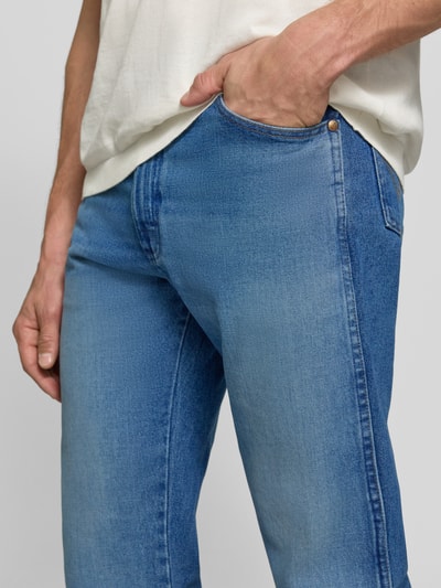 Männermodel trägt Regular Fit Bootcut Jeans aus reiner Baumwolle Modell '13MWZ Cowboy' von Wrangler in Hellblau, Nahaufnahme Oberkörper, Herren Straight Fit Jeans von Wrangler.