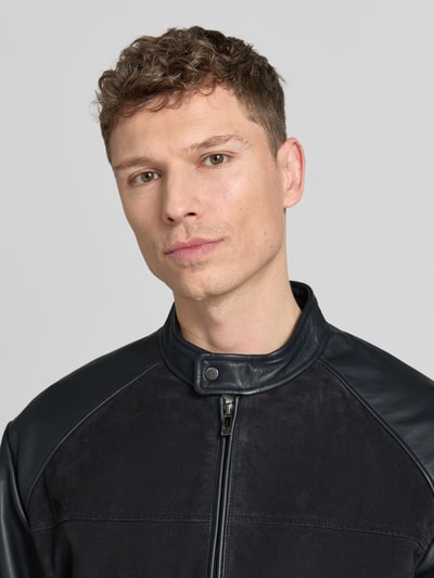 Männermodel trägt Lederjacke mit Zweiwege-Reißverschluss und Eingrifftaschen von ARMANI EXCHANGE in Schwarz, Nahaufnahme Oberkörper.