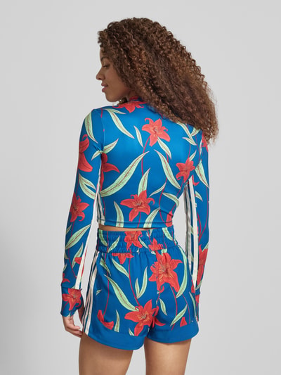 Frauenmodel trägt Slim Fit Sport-Langarmshirt mit Allover-Muster von adidas Sportswear in Blau mit floraler Optik, Kontraststreifen, hochgeschlossenem Ausschnitt, AEROREADY, Materialverarbeitung Interlock, Ganzkörperansicht Rückansicht.