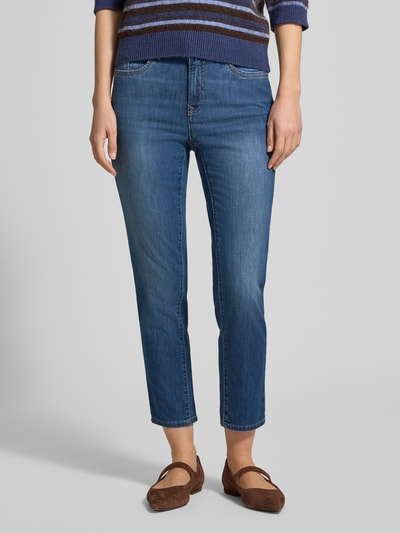 Modelka nosi Jeans in verkürzter Passform Modell 'Mary' od Brax, bawełniany miks ze stretchem, fason skrócony, z kieszeniami ukośnymi, szerokość w rozmiarze 36: 37 cm, długość nogawki od wewnątrz w rozmiarze 36: 69 cm, kolor niebieski, faktura gładka, całkowity widok z przodu.