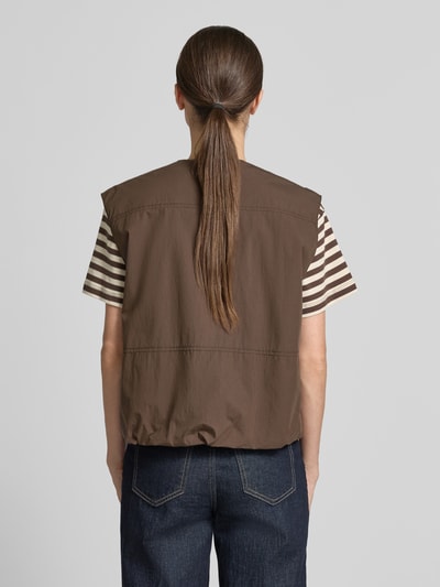 Frauenmodel trägt Weste mit Rundhalsausschnitt und Pattentaschen von camel active aus Baumwoll-Mix, Regular-Fit, Rückenlänge 27 cm, Schulterbreite 45 cm, Brustweite 56 cm, braun, strukturierte Oberfläche, Ganzkörperansicht Rückansicht.