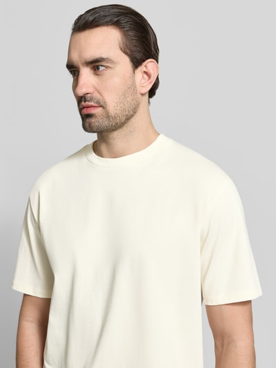 Mannelijk model draagt Oversized T-Shirt mit Rundhalsausschnitt van Lindbergh in crème, pure katoen, oversized fit, halve mouwen, ronde hals, ruglengte maat M 71 cm, close-up bovenlichaam voorkant.