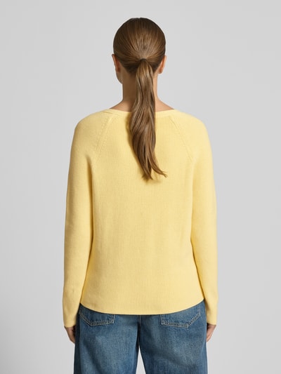 Modelka kobieca ma na sobie Regular Fit Strickpullover aus reiner Baumwolle od Tommy Hilfiger, żółty sweter z długim rękawem i dekoltem w serek, wzór jednolity, logo, rippstrick bawełna, widok całej sylwetki z tyłu.
