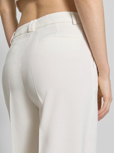 Frauenmodel trägt Stoffhose aus Viskose-Mix mit Bügelfalte von More & More, Gesäßleistentaschen, cremefarben, Detailaufnahme Rückansicht. Damen Stoffhose, Viskose-Mix mit Stretch-Anteil, Wide Leg Fit, Haken- und Reißverschluss, Bundweite bei Größe 36: 36 cm, Innenbeinlänge bei Größe 36: 80 cm.