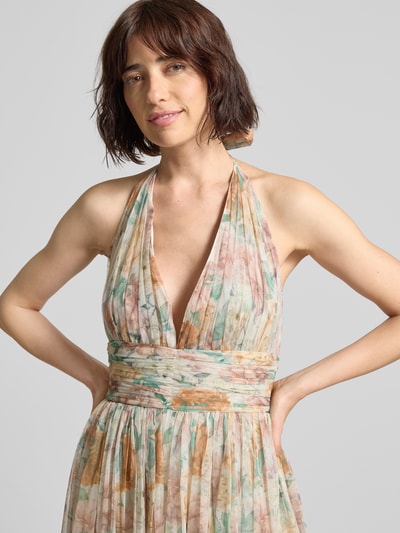 Frauenmodel trägt Cocktailkleid mit Neckholder und Schnürung von LACE & BEADS aus Chiffon, florale Muster in Pastelltönen, A-Linie, Nahaufnahme Oberkörper. Rückenlänge bei Größe S 135 cm, Brustweite 40 cm.