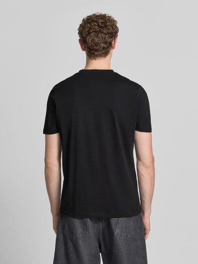 Mannelijk model draagt Regular Fit T-shirt uit zuivere katoen van s.Oliver RED LABEL in effen zwart, glad oppervlak, geheellichaamsaanzicht achteraan.