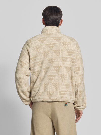 Männermodel trägt Fleecepullover mit Label-Details Modell 'Timber Crest™' von Columbia in Beige mit Muster, Ganzkörperansicht Rückansicht. Gerade geschnitten, Stehkragen, Struktur sichtbar, Rückenlänge 70 cm, Ärmellänge 73 cm.