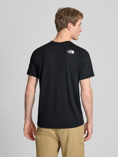 Männermodel trägt T-Shirt mit Logo und Rundhalsausschnitt von The North Face, regular fit, zwarte kleur, ruglengte maat M 69 cm, ganzkörperansicht rückansicht.