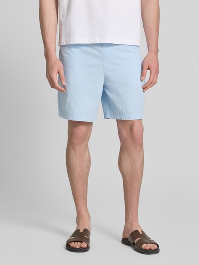 Männermodel trägt Regular Fit Shorts aus reiner Baumwolle Modell 'STUART' von SELECTED HOMME in Hellblau mit Seersucker-Struktur, unifarben, elastischer Bund, seitliche Eingrifftaschen, Gesäßtaschen, Nahaufnahme Oberkörper bis Knieansicht von vorne.