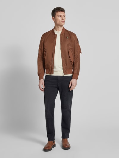 Männermodel trägt Jacke mit Zweiwege-Reißverschluss Modell 'Rocky' von Blauer Usa in Braun, Regular Fit, Stehkragen, Pattentaschen, Ganzkörperansicht von vorne. Rückenlänge 65 cm, Schulterbreite 46 cm, Brustweite 58 cm, Ärmellänge 65 cm.
