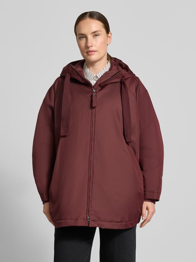 Frauenmodel trägt Relaxed Fit Mantel mit Kapuze Modell 'PURE' von g-lab in Bordeaux, glatte Struktur, mit Tunnelzug und Eingrifftaschen, Ganzkörperansicht von vorne. Rückenlänge, Schulterbreite, Brustweite und Ärmellänge bei Größe S laut Kontextinformation.