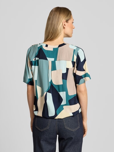 Frauenmodel trägt Regular Fit Blusenshirt aus reiner Viskose von Tom Tailor, mehrfarbiges Popeline mit grafischem Muster, Ganzkörperansicht Rückansicht.
