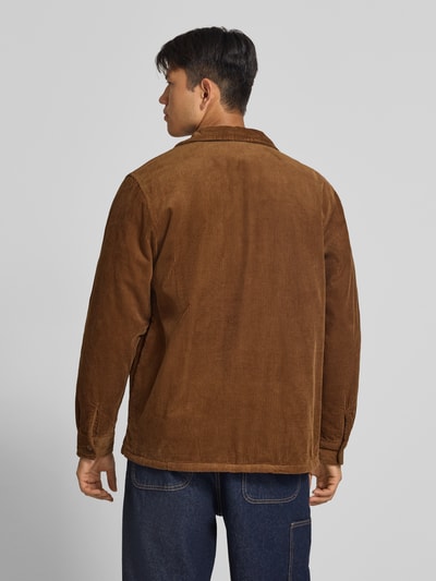 Männermodel trägt Regular Fit Hemdjacke aus Cord Modell 'WHITSOME' von Carhartt Work In Progress, brauner Baumwollcord, Rückenansicht. Kontext: Herren Hemdjacke mit Umlegekragen, Brusttaschen, Seitentaschen, Label-Patch, Größe M Rückenlänge 77 cm, Schulterbreite 50 cm, Ärmellänge 67 cm.