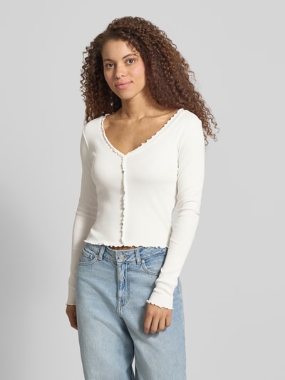 Vrouwenmodel draagt Slim Fit Langarmshirt aus Baumwoll-Mix Modell 'LAILA' van Only, unifarben, fijnrib, cropped, met knopen, lange mouw, muschelsaum, Ganzlichaamsvoorzijde.