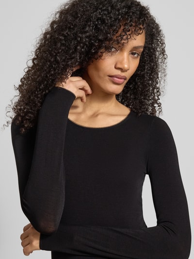 Kobiece model prezentuje Slim Fit langärmliges Unterhemd mit Woll-Anteil Model 'B.PURE' od BOSS, efekt: jednolity kolor, krój slim fit, okrągły dekolt, długi rękaw, dama podkoszulki, zbliżenie na górną część ciała.