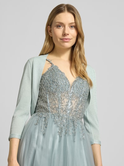 Modelka kobieca nosi Regular Fit Bolero aus Viskose-Mix od Jake*s Cocktail, kolor jasnozielony, efekt połysku, dzianinowa faktura, rękaw 3/4, długość tyłu w rozmiarze 36: 33 cm, zbliżenie na górną część ciała z przodu
