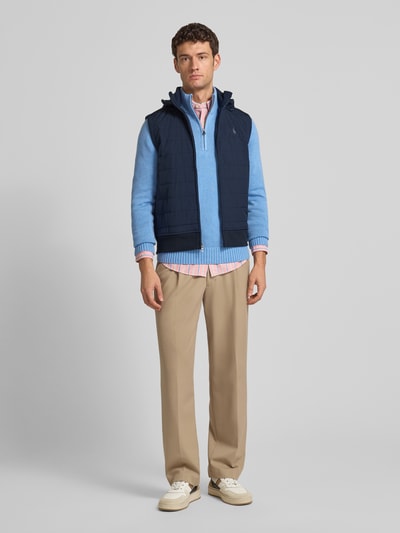 Männermodel trägt Steppweste mit Kapuze und Label-Stitching von Polo Ralph Lauren in Dunkelblau, Regular Fit, Ganzkörperansicht von vorne, Kapuze mit Tunnelzug, Stehkragen, Reißverschluss, Rückenlänge 31 cm, Schulterbreite 42 cm, Brustweite 58 cm.