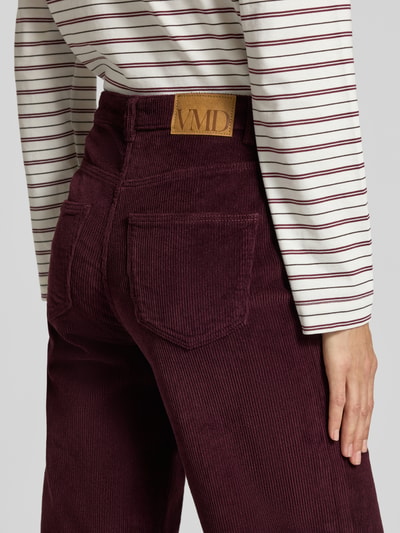 Männermodel trägt Wide Leg Hose aus Baumwoll-Mix Modell 'TESSA' von VERO MODA in Dunkelrot, samtige Textur, Nahaufnahme Rückansicht, Damen Weite Hose von VERO MODA