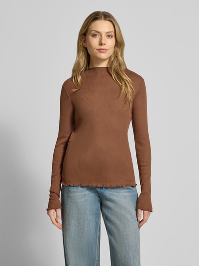 Modelka kobieca ma na sobie Slim Fit Langarmshirt mit Viskose-Anteil od s.Oliver RED LABEL, brązowy, dzianinowy, krój slim fit, rippstrick, frill na rękawach i dole, stitchowana aplikacja label, góra zakryta, długie rękawy; widok całej sylwetki z przodu.