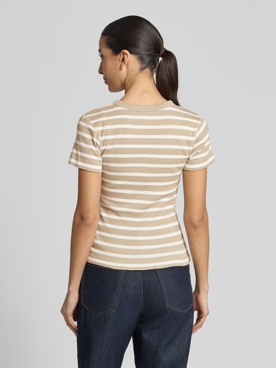 Modelka nosi damski t-shirt z bawełny marki Drykorn, dopasowany krój, drobne prążkowanie, okrągły dekolt, model 'KOALE', długość tyłu w rozmiarze S: 52 cm. Ganzkörperansicht Rückansicht.