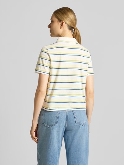 Modelka nosi Regular Fit Poloshirt aus reiner Baumwolle von s.Oliver RED LABEL, efekt: w paski, krój regular fit, kołnierzyk polo, dekolt w serek, krótkie rękawy, drobne prążkowanie, z bawełny, wielokolorowe, widok całej sylwetki od tyłu.