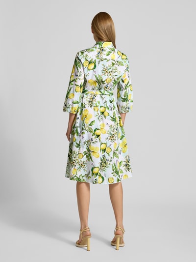 Vrouwenmodel draagt Hemdblusenkleid im Allover-Look met bindegürtel van Marc Cain in witte en gele tinten, zuivere katoen, a-lijn, midikleed, allover-print, bindriem, ruglengte 113 cm, borstwijdte 45 cm, mouwlengte 47 cm, volledige lichaamsaanzicht achteraan.