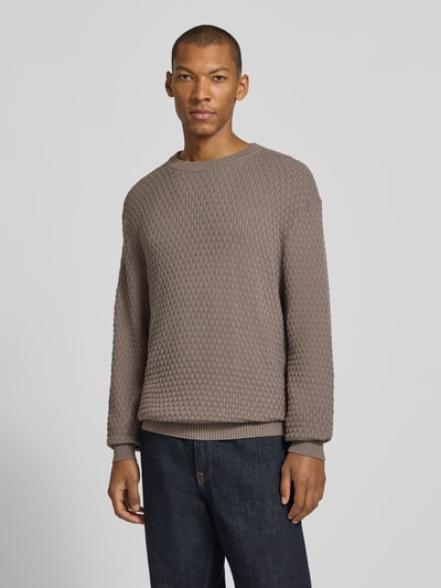 Männermodel trägt Regular Fit Pullover aus reiner Baumwolle Modell 'Sylas' von HUGO in Taupe mit strukturierter Oberfläche, Ganzkörperansicht von vorne, Herren Pullover von HUGO.