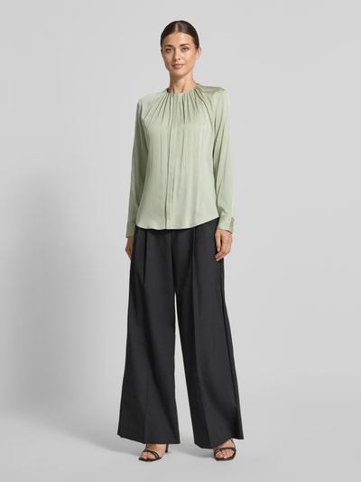 Vrouwenmodel draagt Regular fit blouse met lange mouwen van zijdemix model 'Banorah' van BOSS in lichtgroen met zwarte broek, dames, full-body frontaal.