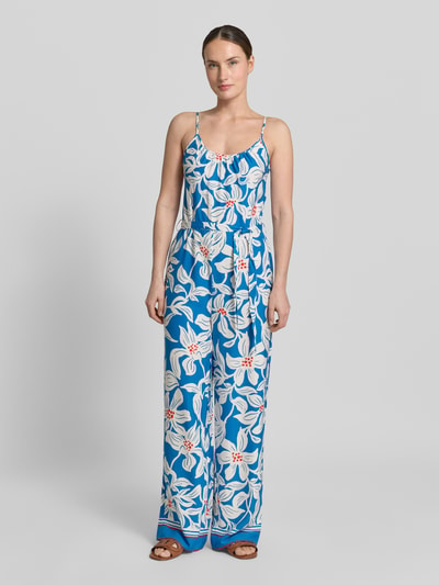 Vrouwenmodel draagt Jumpsuit uit zuiver viscose met spaghettibandjes model 'Rylie' van GUIDO MARIA KRETSCHMER WOMAN, getailleerd model, ronde hals, strikceintuur, bloemenprint in blauw en wit, totale lengte maat 36: 128 cm, borstwijdte: 32 cm, binnenbeenlengte: 78 cm, voorkant hele lichaamsopname.