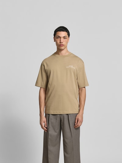 Männermodel trägt Relaxed Fit T-Shirt aus reiner Baumwolle von ANNARR in Beige, Label-Print, Rundhalsausschnitt, Kurzärmelig, Rückenlänge 67 cm bei Größe M, Ganzkörperansicht von vorne.