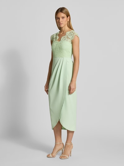 Frauenmodel trägt Midikleid mit Spitze Modell 'CLARA' von Vila in zartem Mintgrün, taillierter Schnitt, V-Ausschnitt, Material-Mix, Ganzkörperansicht von vorne.