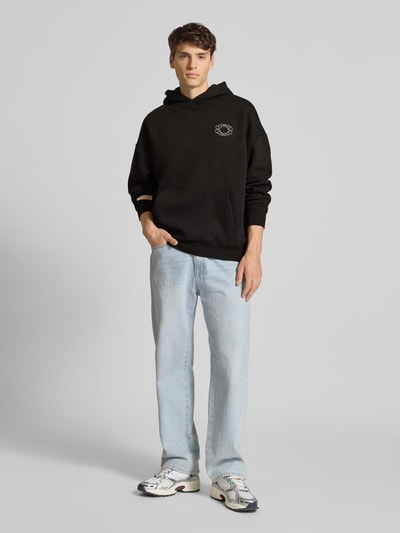 Mannelijk model draagt Hoodie met Kapuze van PROHIBITED in zwart, katoenmix, loose fit, met buidelzak en logo-detail, voorkant volledige lichaamsweergave.