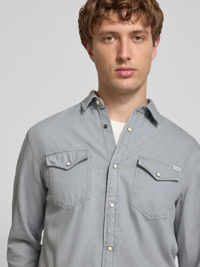 Männermodel trägt Slim Fit Freizeithemd mit Kentkragen Modell 'ESHERIDAN' von JACK & JONES aus Baumwolle, Nahaufnahme Oberkörper.