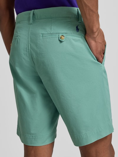Männermodel trägt Straight Fit Chinoshorts aus katoenmix van Polo Ralph Lauren, effen kleuren, logodetail, riemlussen, knoop- en ritssluiting, achterzakken, steekzakken, Ganzkörperansicht Rückansicht.