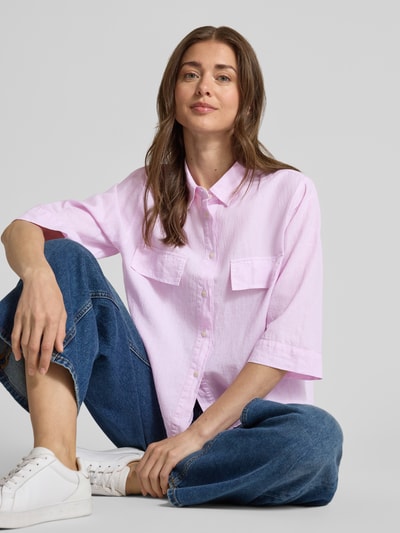 Kobiece model nosi bluzka z mieszanki lnu i bawełny z kieszeniami na piersi, model 'BEA' od 0039 Italy, krój loose fit, kołnierzyk koszulowy, listwa guzikowa, rękaw o dł. 3/4, długość tyłu w rozmiarze S: 57 cm, długość rękawów w rozmiarze S: 37 cm, kolor jasnoróżowy, struktura gładka, szerokie dżinsy, białe sneakersy, ujęcie całej sylwetki z przodu.
