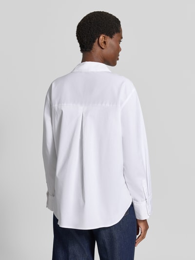 Frauenmodel trägt Regular Fit Langarmbluse aus Baumwoll-Mix Modell 'LOTUS' von VERO MODA, jednokolorowy, kołnierzyk koszulowy, detal: pas na plecach z kontrafałdą, wysoki dekolt, listwa guzikowa, długi rękaw z mankietem, wykończenie zaokrąglone, brustasza, popelina, mieszanka bawełny, widok całej sylwetki od tyłu.