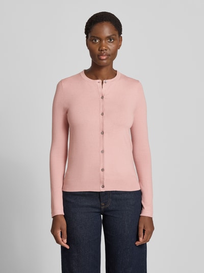 Vrouwenmodel draagt Regular Fit gebreid jack uit viscosemix met geschulpte zoom van Christian Berg Woman, lichtroze, knoopsluiting, lange mouw, ribboorden, ruglengte maat S 56 cm, mouwlengte maat S 61 cm, voorkantaanzicht bovenlichaam
