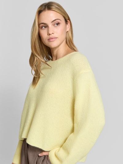 Frauenmodel trägt Strickpullover aus Alpaka-Leinen-Mix Modell 'VITOW' von American Vintage in Hellgelb, lockere Passform, Nahaufnahme Oberkörper. Damen Strickpullover von American Vintage, Alpaka-Leinen-Mix mit Stretch-Anteil, Rundhalsausschnitt, Rückenlänge bei Größe S: 53 cm, Ärmellänge bei Größe S: 61 cm.