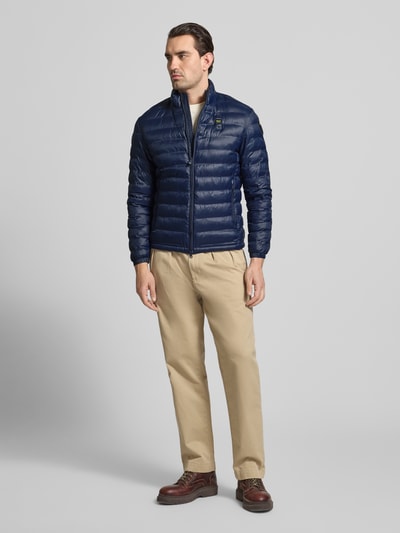 Männermodel trägt Regular Fit Jacke in Stepp-Optik Modell 'Sewall' von Blauer Usa, dunkelblau, Ganzkörperansicht von vorne. Herren Jacke mit Zweiwege-Reißverschluss, gefüttertem Stehkragen, Logo-Patch und Reißverschluss-Eingrifftaschen, Maße: Rückenlänge 70 cm, Schulterbreite 44 cm, Brustweite 52 cm, Ärmellänge 64 cm.