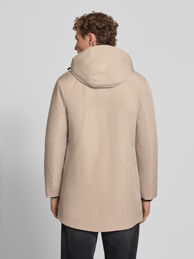 Męski model nosi Regular Fit Parka mit Logo-Print od Lindbergh, elastyczna mieszanka materiałów, beżowy kolor, kaptur z tunelem, zamek błyskawiczny, długość tyłu w rozmiarze M: 90 cm, szerokość ramion w rozmiarze M: 50 cm, szerokość klatki piersiowej w rozmiarze M: 58 cm, długość rękawów w rozmiarze M: 65 cm, widok całej sylwetki od tyłu.