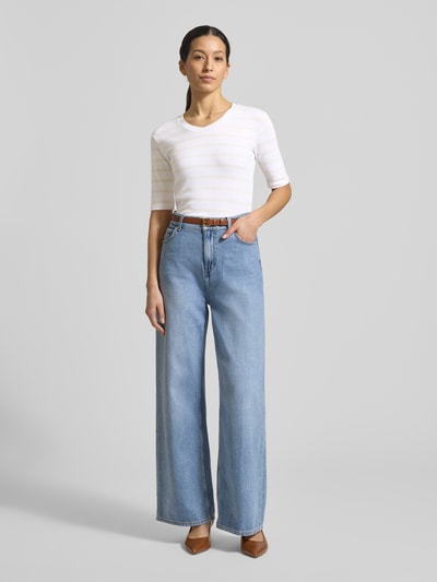 Vrouwenmodel draagt T-shirt met streepmotief en V-hals van Christian Berg Woman, mix van katoen en elastaan, regular fit, ruglengte bij maat S 55 cm, all-over streepmotief in wit en lichtbeige, rechte vormen, glad textuur. Volledige lichaamsaanzicht van voren.