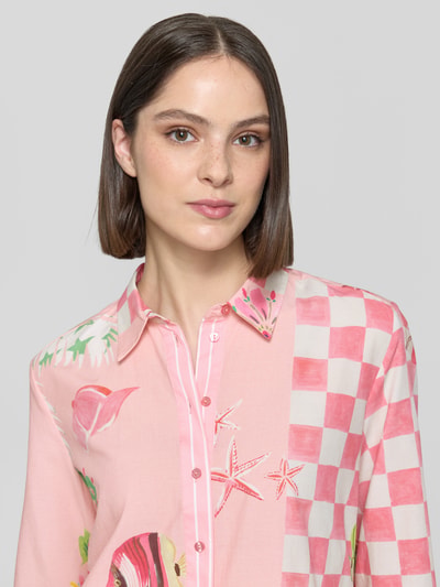 Frauenmodel trägt Bluse aus Viskose-Mix mit Knopfleiste Modell 'Crazy Shirt' von Smith and Soul, Muster in Rosa und Weiß, Nahaufnahme Oberkörper, Damen Bluse, Viskose-Mix mit Baumwoll-Anteil, Loose Fit, Hemdblusenkragen, Knopfleiste, 3/4-Arm, Rückenlänge bei Größe S: 64 cm, Ärmellänge bei Größe S: 44 cm.