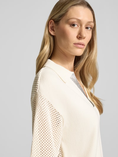 Modelka kobieca nosi Relaxed Fit Poloshirt in Strick-Optik mit Strasssteinbesatz od LIU JO SPORT z bawełny, imitacja dzianiny, obszycie z kamieni stras, perforowane krótkie rękawy, kolor kremowy, widok z przodu zbliżenie na górę ciała.