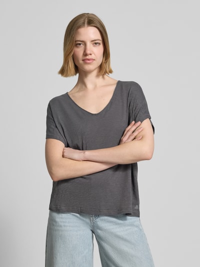 Kobiece model nosi Loose Fit T-Shirt aus reiner Baumwolle od Marc O'Polo, w efekcie melanżu, krój loose fit, dekolt w serek, krótki rękaw, wykonany z czystej bawełny, szara kolorystyka, faktura melanżu, całościowy widok z przodu.